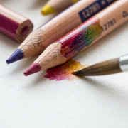 Macro view of water activating Staedtler watercolor pencils and wood grain, showing the "12781" marking on texture paper.