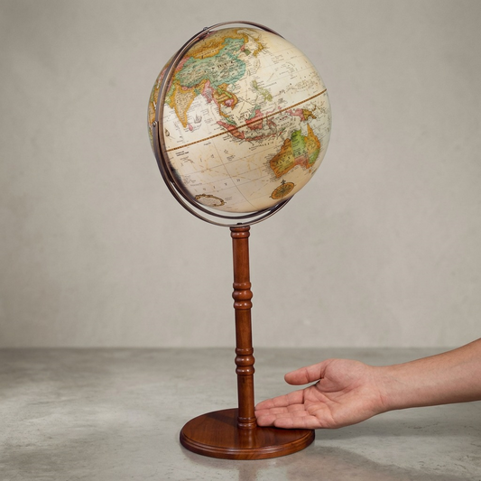 A photo of the 16-inch Commander II antique floor globe next to a human hand for scale.